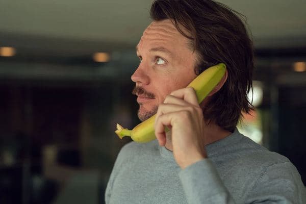 En av de ansatte i Jobbfrukt holder en banan som en telefon i en av kampanjefilmene