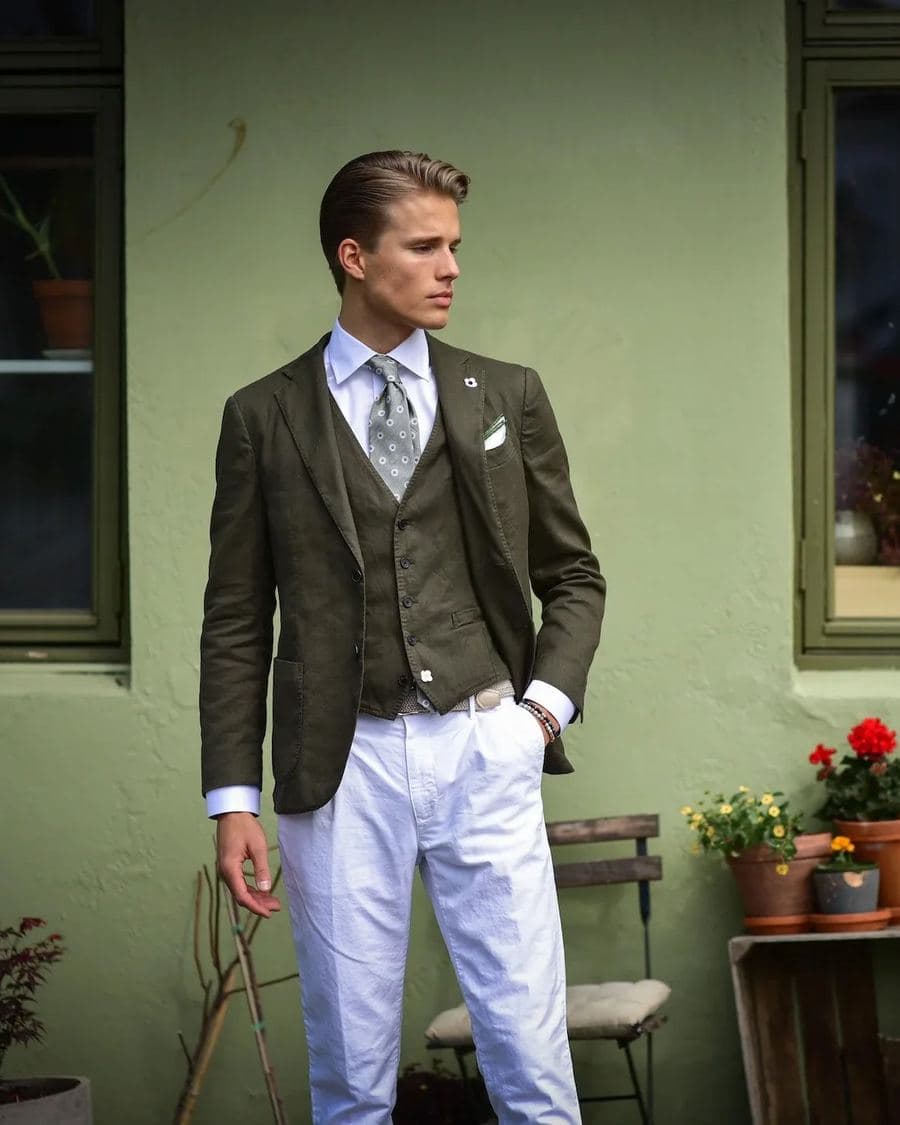 Modell i grønn tweeddress fra Scabal foran en grønn murvegg